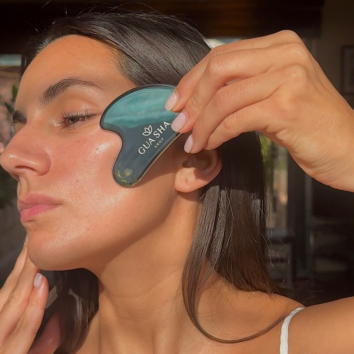 woman using Stainless steel gua sha on face